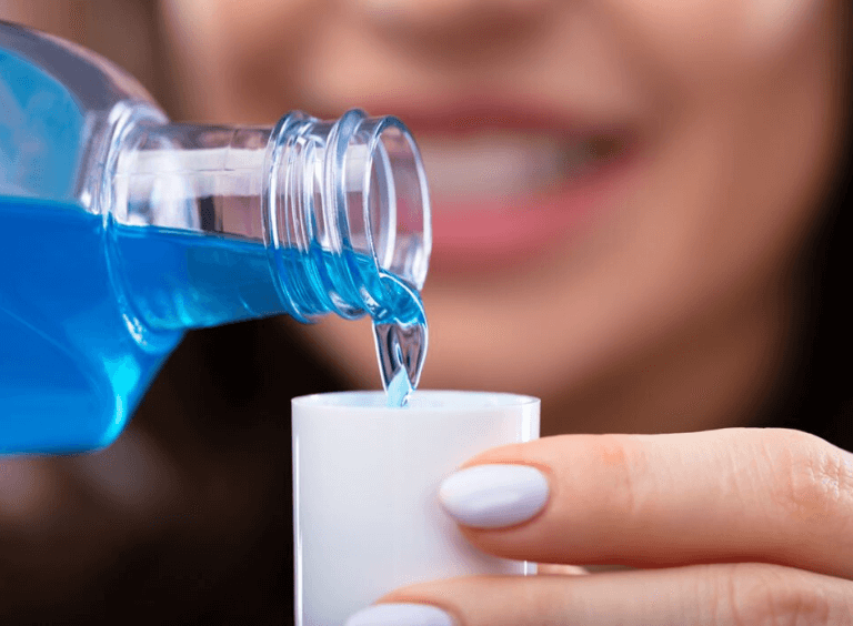 Woman pouring mouthwash at Harwood Dental Practice