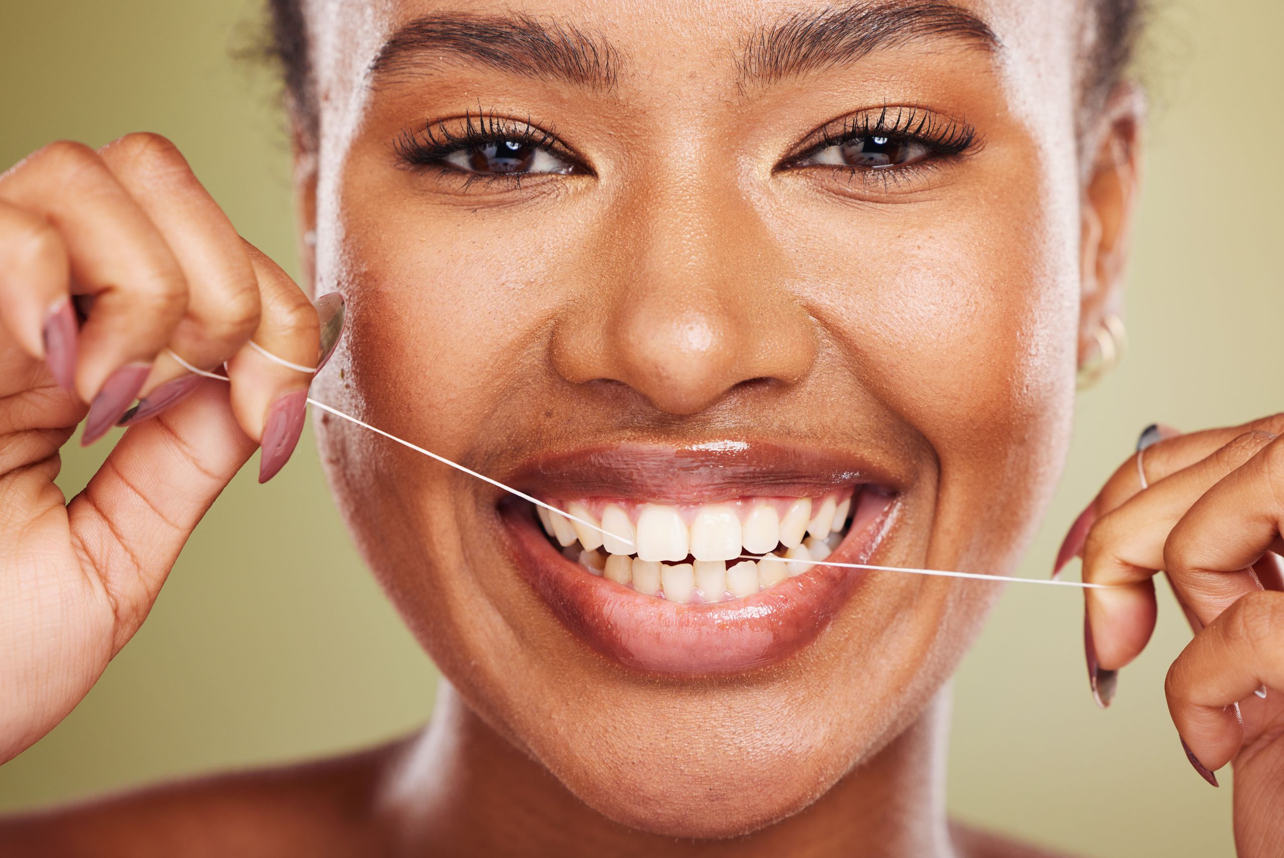 Woman smiling widely and flossing